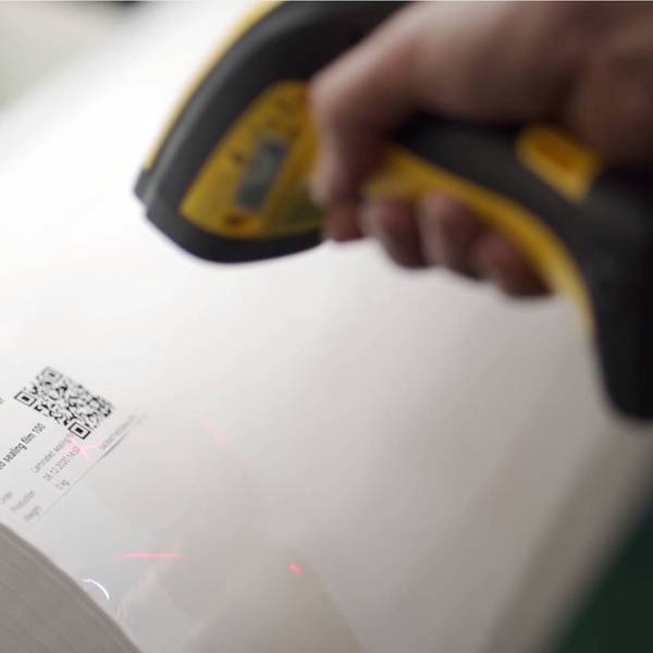 Ein Scanner ist auf den QR-Code einer Folienrolle gerichtet.