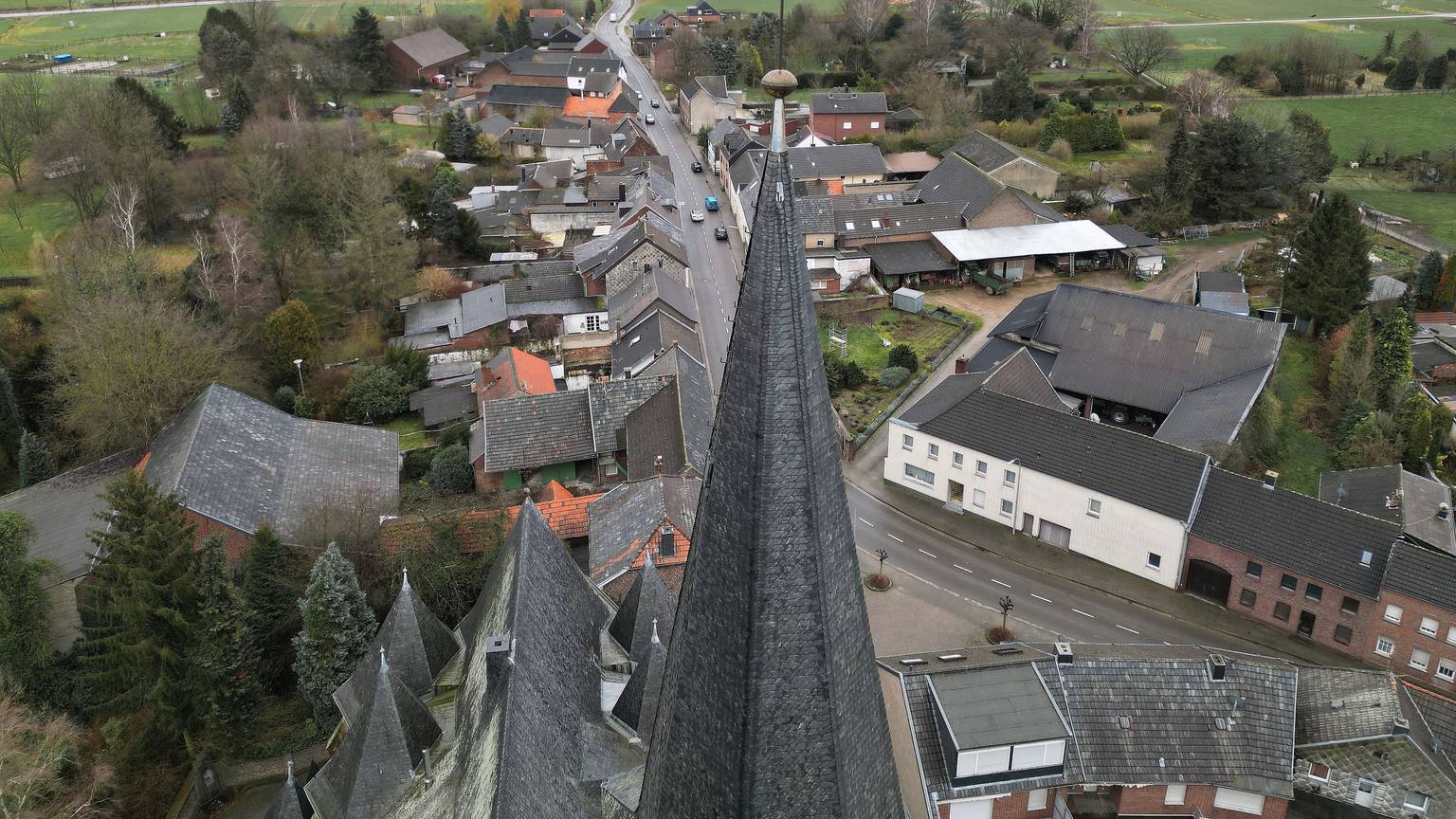05.02.2023, Nordrhein-Westfalen, Erkelenz: Die Kirche von Keyenberg steht knapp 500m von der RWE Braunkohle Tagebau Garzweiler (Aufnahme mit einer Drohne). Durch das auf 2030 vorgezogene Ende der Braunkohleförderung bleiben fünf Dörfer zwischen dem Stadtkern von Erkelenz und dem Tagebau Garzweiler erhalten.
Aus den Dörfern, um die es geht, sind schon 90 Prozent der ursprünglichen Bewohner weggezogen, die meisten Häuser stehen leer. Sie gehören überwiegend dem Energiekonzern RWE. Von den ursprünglich 1500 Bewohnern sind noch 200 verblieben. Hinzu kommen derzeit 300 Geflüchtete aus der Ukraine, die in Häusern leben. Heute findet ein Dorfspaziergang von evangelischer Kirche, Klimabewegung und Landwirtschaft nahe dem Braunkohleabbau statt. Foto: David Young/dpa +++ dpa-Bildfunk +++