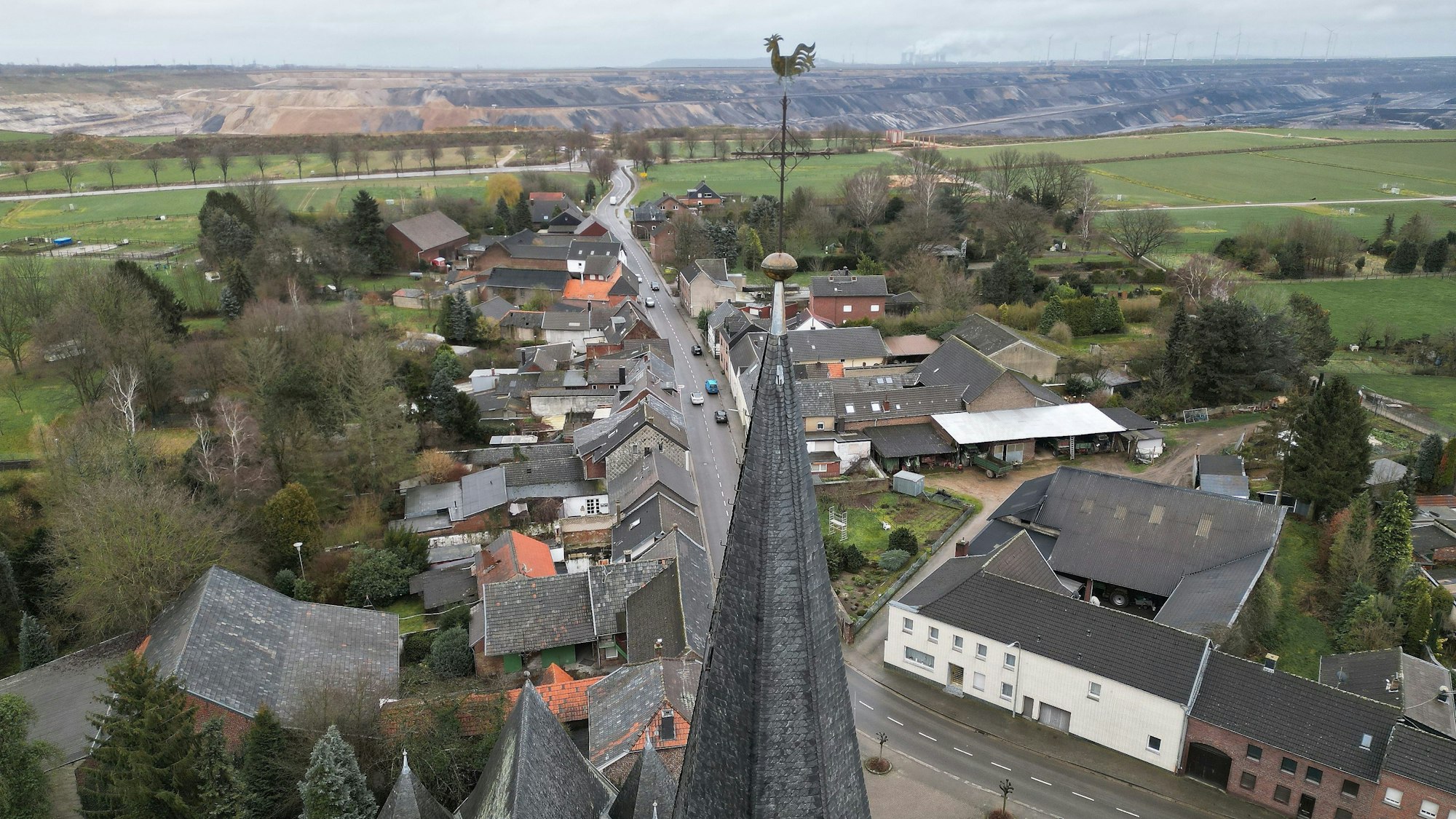 05.02.2023, Nordrhein-Westfalen, Erkelenz: Die Kirche von Keyenberg steht knapp 500m von der RWE Braunkohle Tagebau Garzweiler (Aufnahme mit einer Drohne). Durch das auf 2030 vorgezogene Ende der Braunkohleförderung bleiben fünf Dörfer zwischen dem Stadtkern von Erkelenz und dem Tagebau Garzweiler erhalten.
Aus den Dörfern, um die es geht, sind schon 90 Prozent der ursprünglichen Bewohner weggezogen, die meisten Häuser stehen leer. Sie gehören überwiegend dem Energiekonzern RWE. Von den ursprünglich 1500 Bewohnern sind noch 200 verblieben. Hinzu kommen derzeit 300 Geflüchtete aus der Ukraine, die in Häusern leben. Heute findet ein Dorfspaziergang von evangelischer Kirche, Klimabewegung und Landwirtschaft nahe dem Braunkohleabbau statt. Foto: David Young/dpa +++ dpa-Bildfunk +++