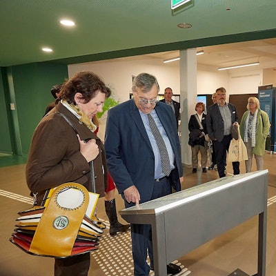 Das Foto zeigt die Teilnehmer der Ausstellungseröffnung an der Karte von Vogelsang.