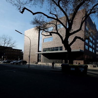 Das Rautenstrauch-Joest-Museum in Köln vor blauem Himmel und einem großen Baum vor der Klinker-Fassade.