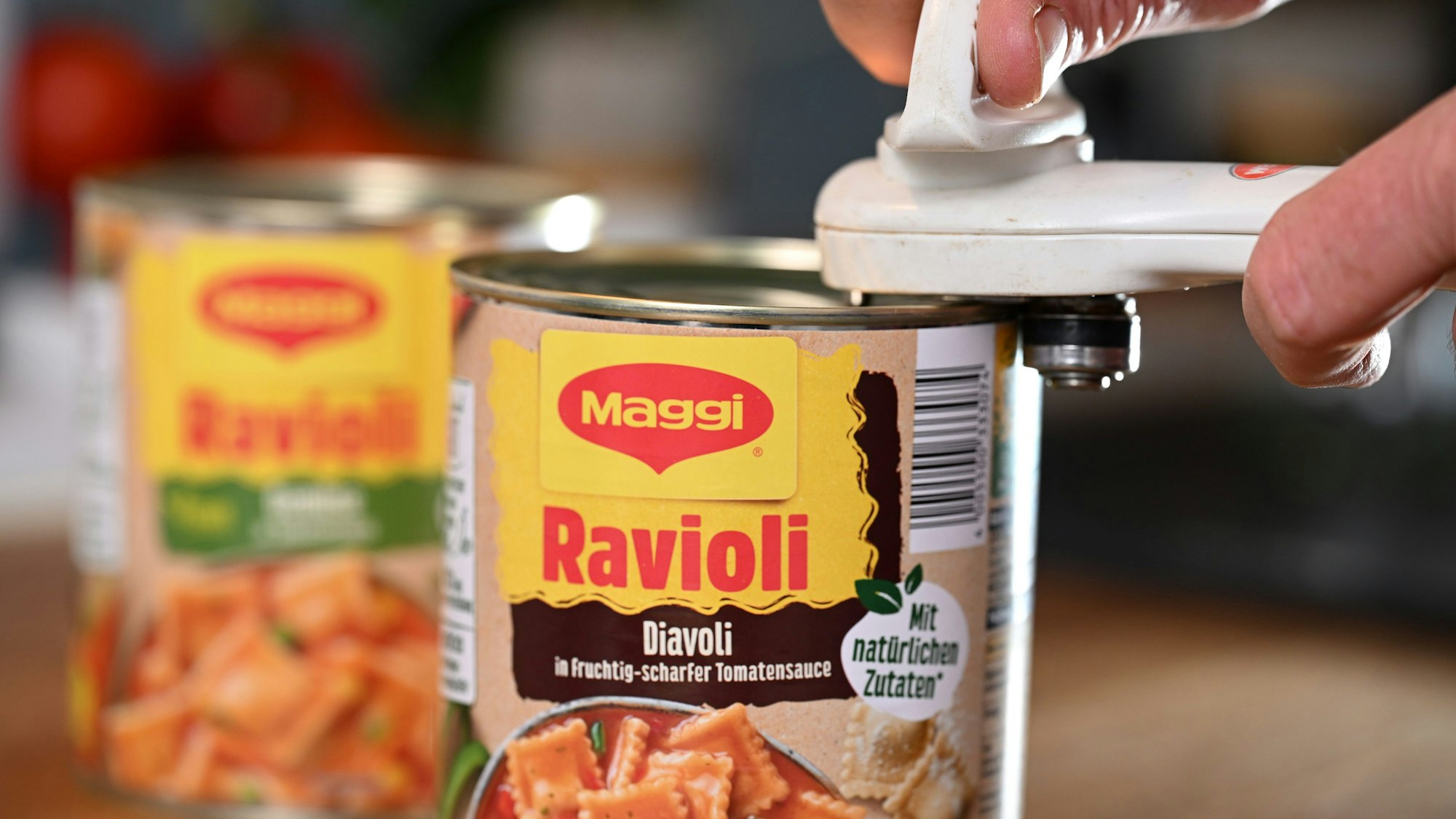 Eine Dose Ravioli von Maggi wird mit einem Dosenöffner geöffnet.