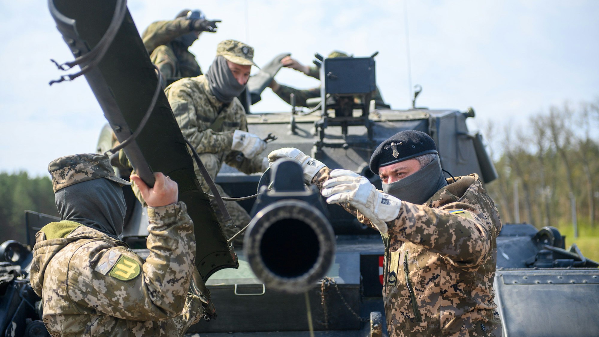 Ukrainische Soldaten arbeiten an der Panzerkanone eines Kampfpanzers vom Typ Leopard 1 A5.