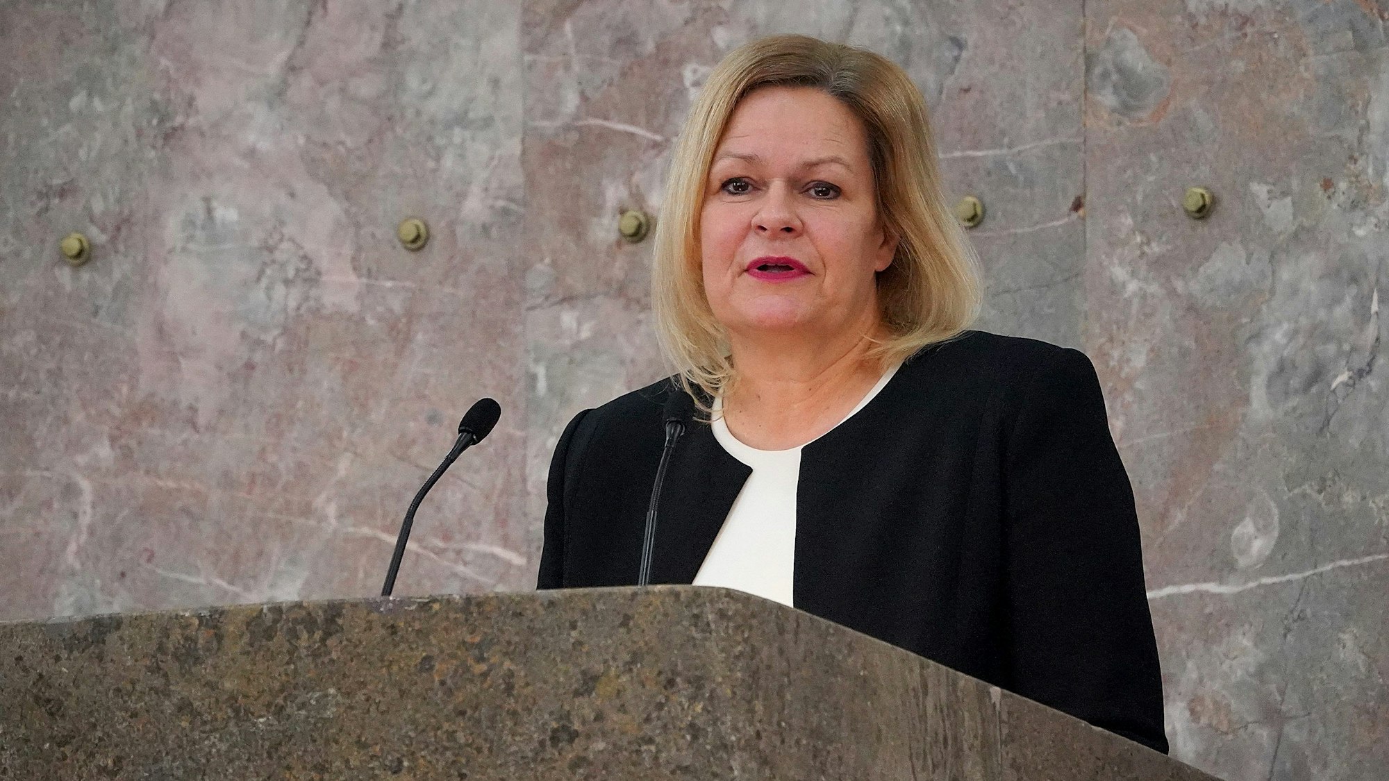 Nancy Faeser spricht an einem Pult