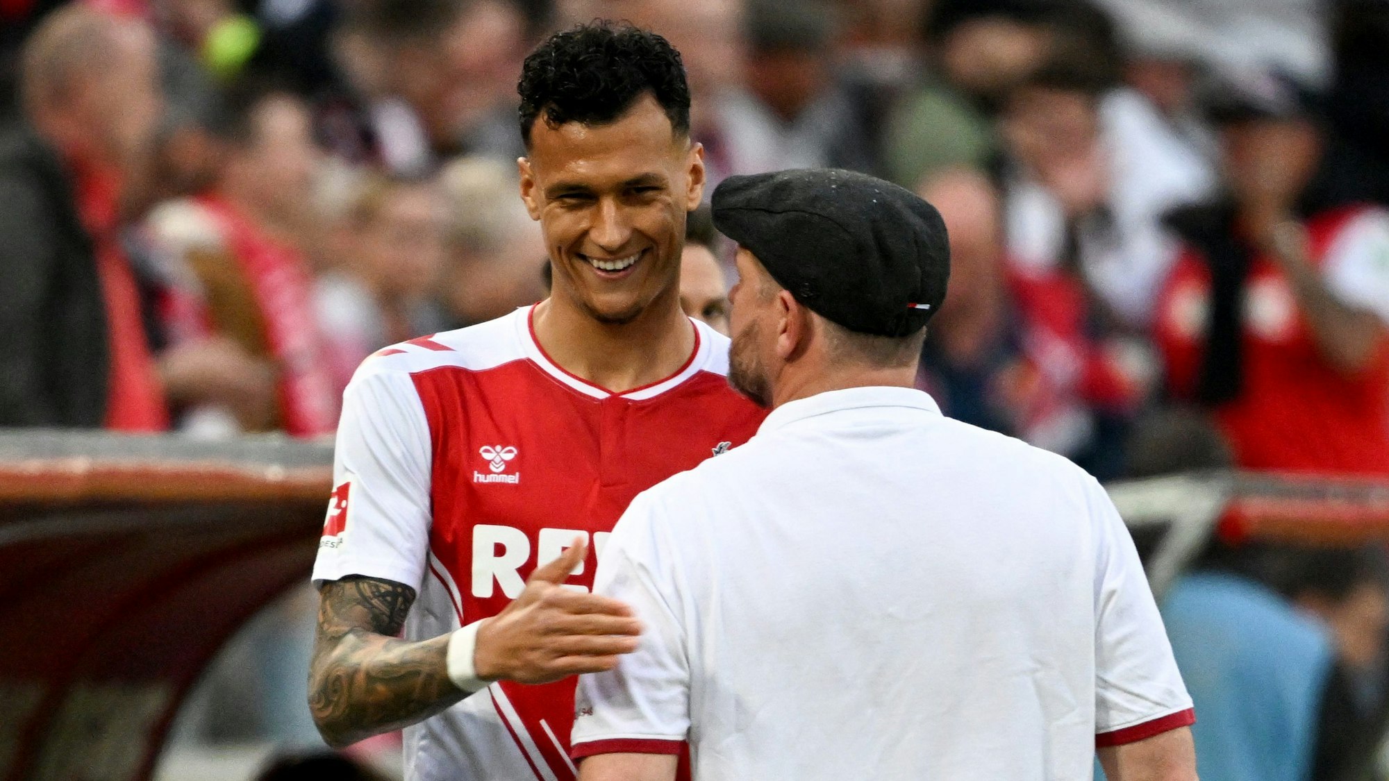 Kölns Davie Selke (l) lächelt am Spielfeldrand neben Kölns Trainer Steffen Baumgart.