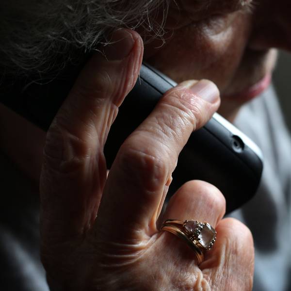 Eine ältere Frau telefoniert mit einem schnurlosen Festnetztelefon.