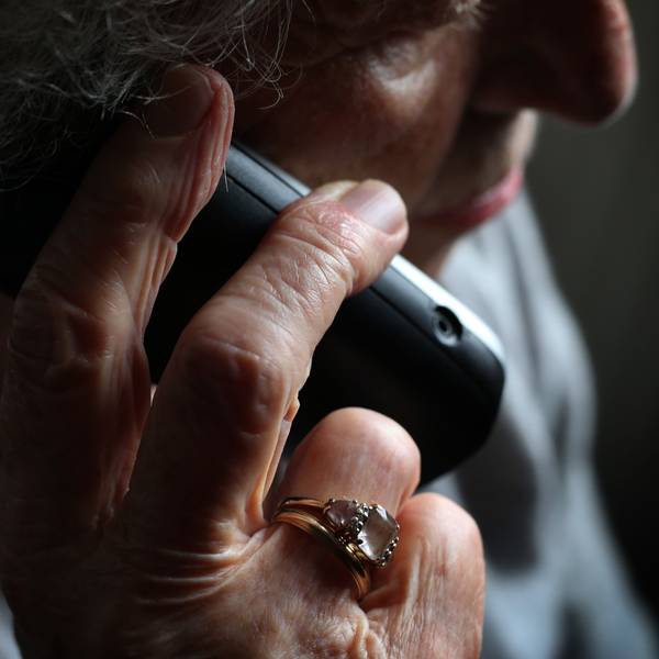 Eine ältere Frau telefoniert mit einem schnurlosen Festnetztelefon.