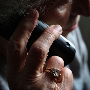 Eine ältere Frau telefoniert mit einem schnurlosen Festnetztelefon.