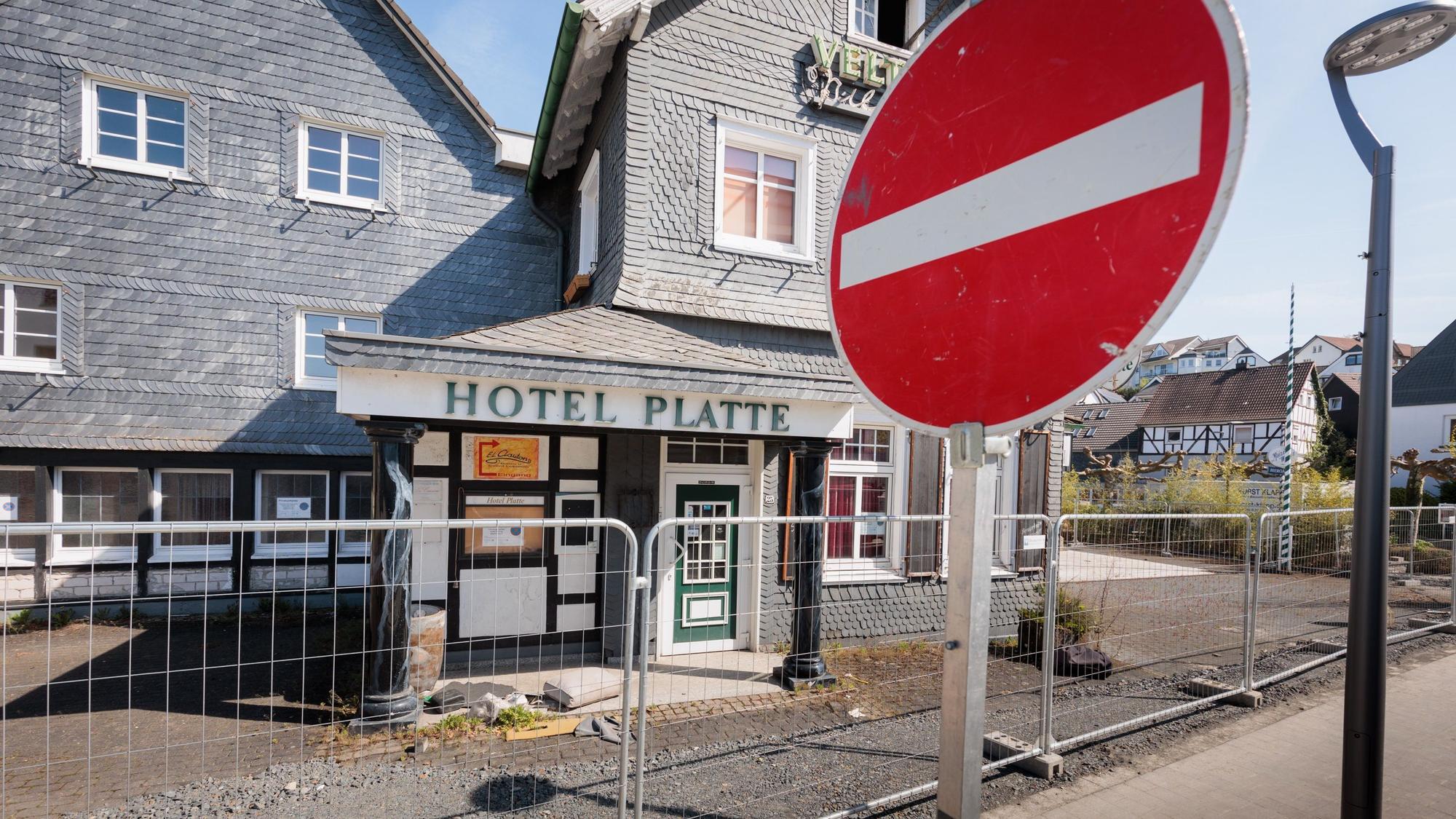 Das Bild zeigt ein "Einfahrt verboten"-Verkehrsschild im Vordergrund, hinter einem Bauzaun steht das Hotel Platte.
