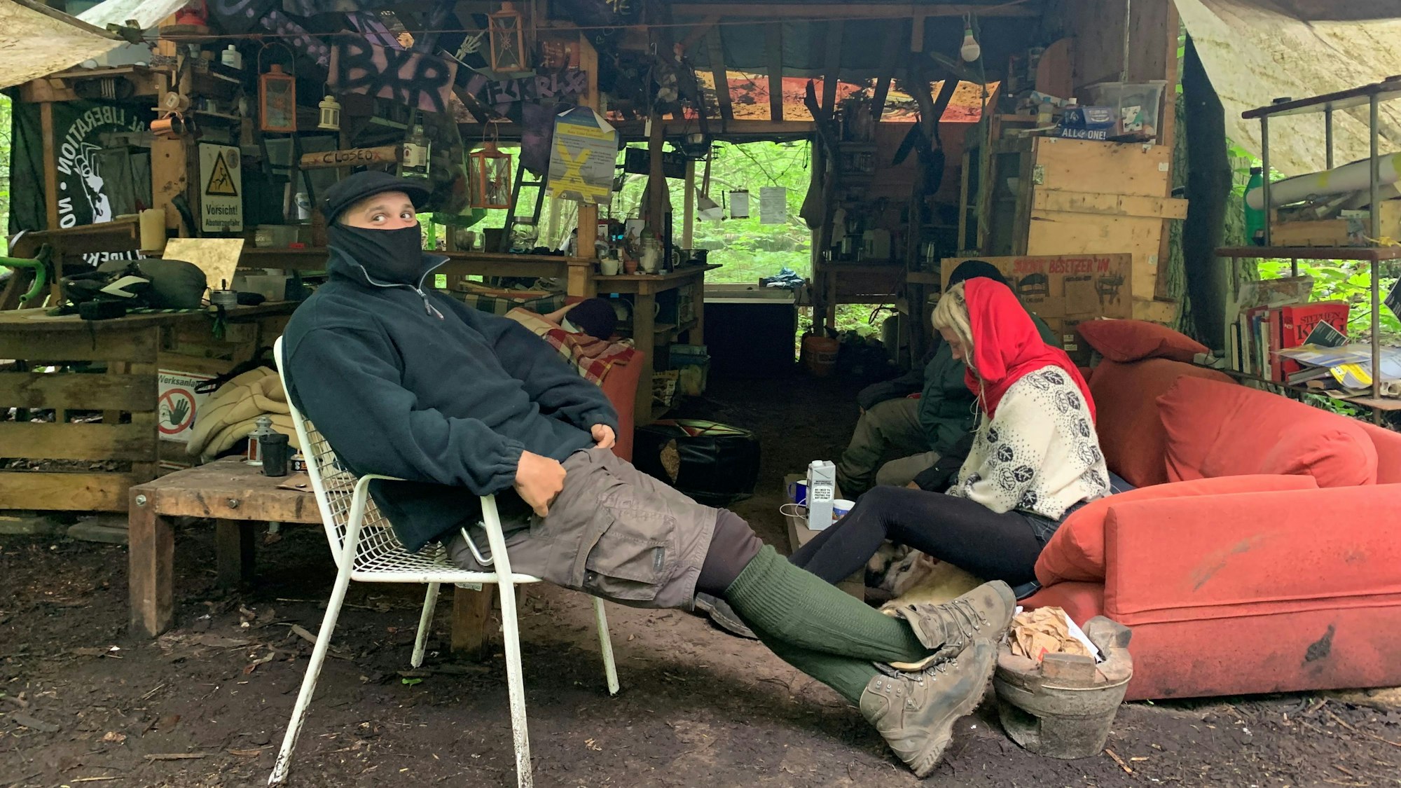 Klimaaktivist Balou von der Initiative "Unser aller Wald" sitzt auf einem Campingstuhl im kleinen Protestcamp im Dorf Keyenberg im Rheinische Revier