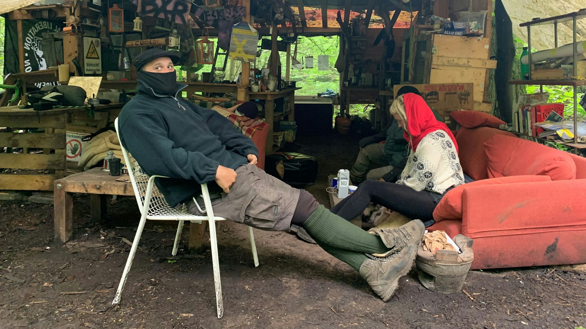 Klimaaktivist Balou von der Initiative "Unser aller Wald" sitzt auf einem Campingstuhl im kleinen Protestcamp im Dorf Keyenberg im Rheinische Revier