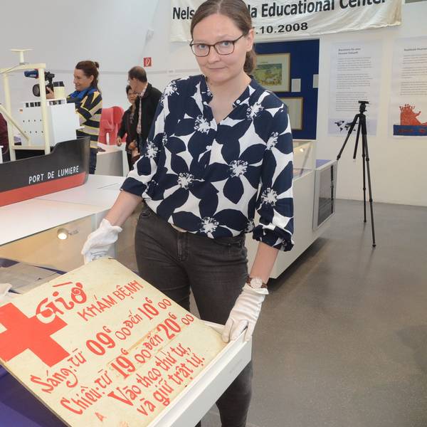 Das Schild, das die Öffnungszeiten der Krankenstation nannte, wird von Kuratorin Bernadette Fischer gezeigt.