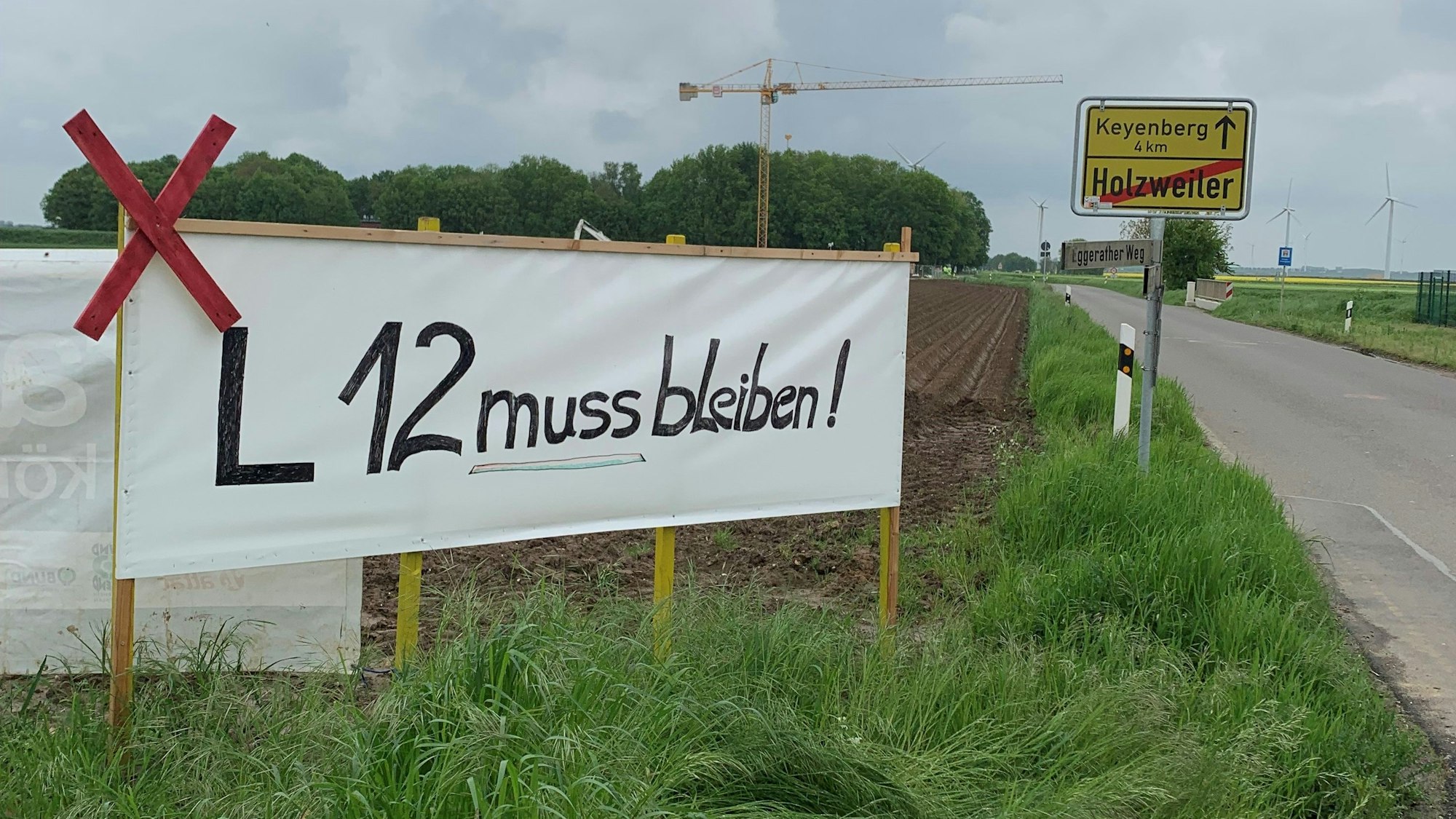Am Ortseingang des Dorfes Holzweiler haben Aktivisten ein Banner platziert. Die Dorfgemeinschaft kämpft um den Erhalt der Landstraße 12, die Anfang Juni 20223 dem Braunkohletagebau weichen soll.