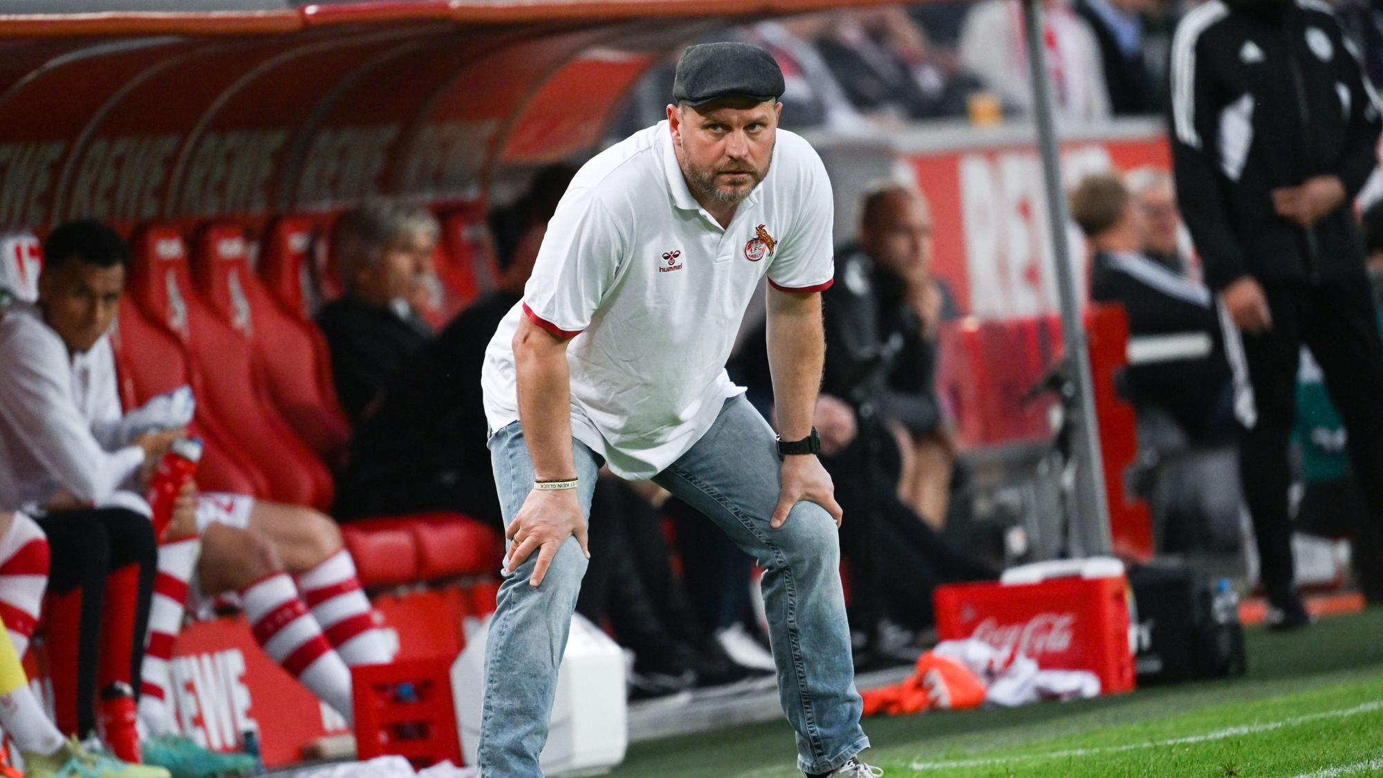 Baumgart stützt am Spielfeldrand beide Hände auf seinen Knien ab.