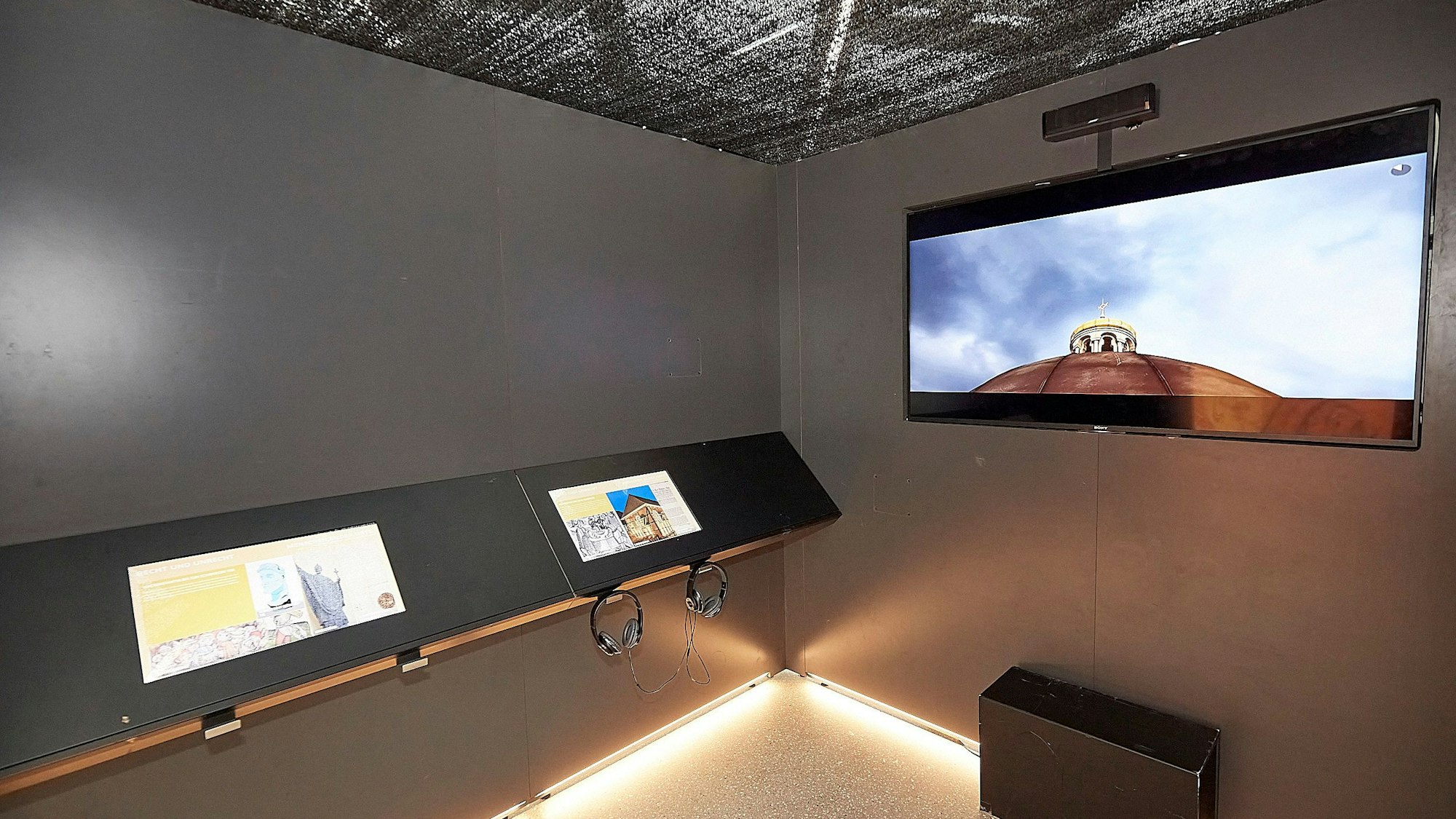 Der Blick in eine der vier Kuben. Ein Großbildschirm zeigt die vorgestellten Objekte.