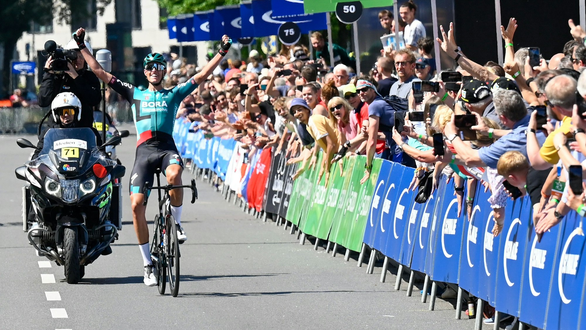 Nils Politt fährt im Mai 2022 jubelnd über den Zielstrich von „Rund um Köln“.