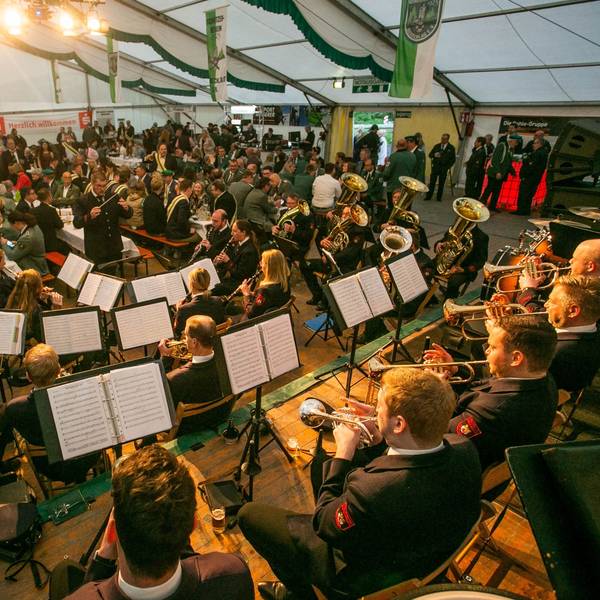 In einem voll besetzten Festzelt spielt ein Musikzug.