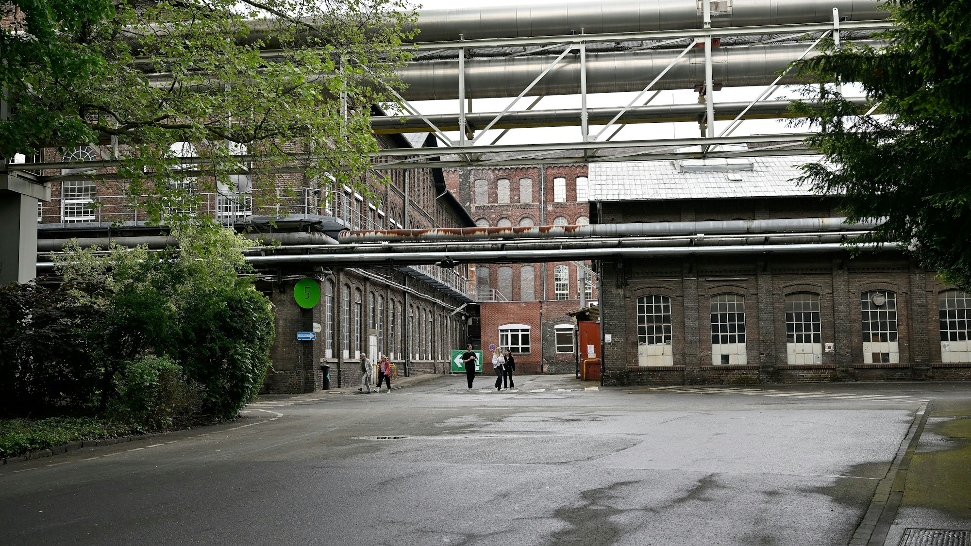 Das Foto zeigt alte Werkshallen und Rohrleitungen auf dem Zanders-Gelände.