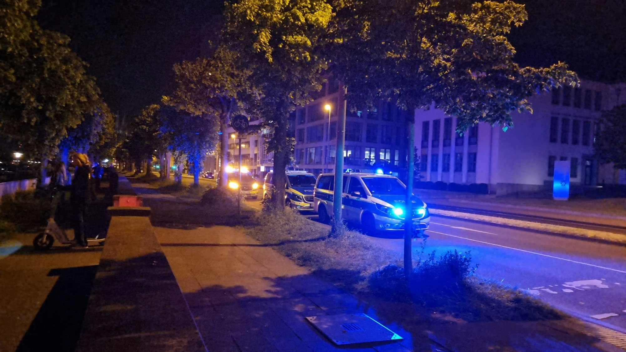 Mehrere Polizeiautos stehen am Rheinufer.