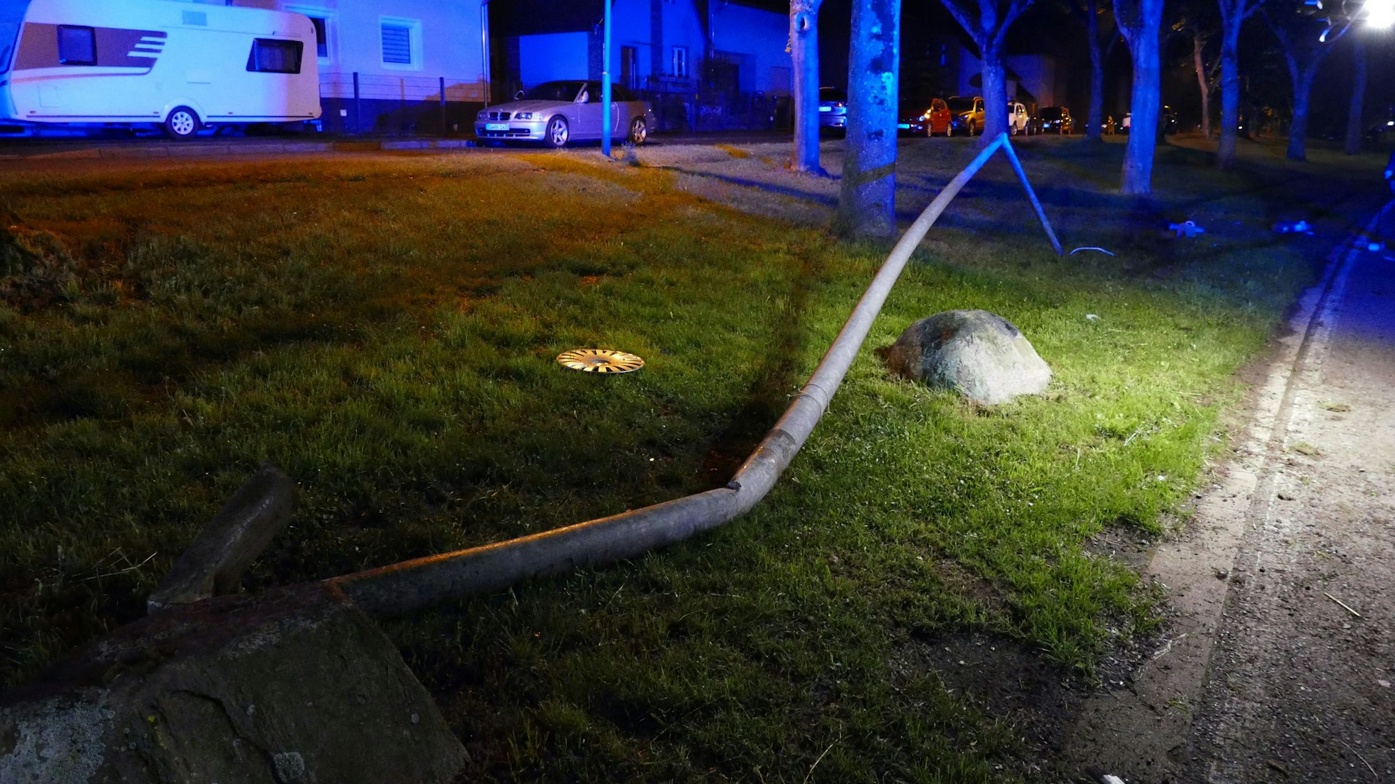 Eine verbogene Laterne liegt auf einer Wise.