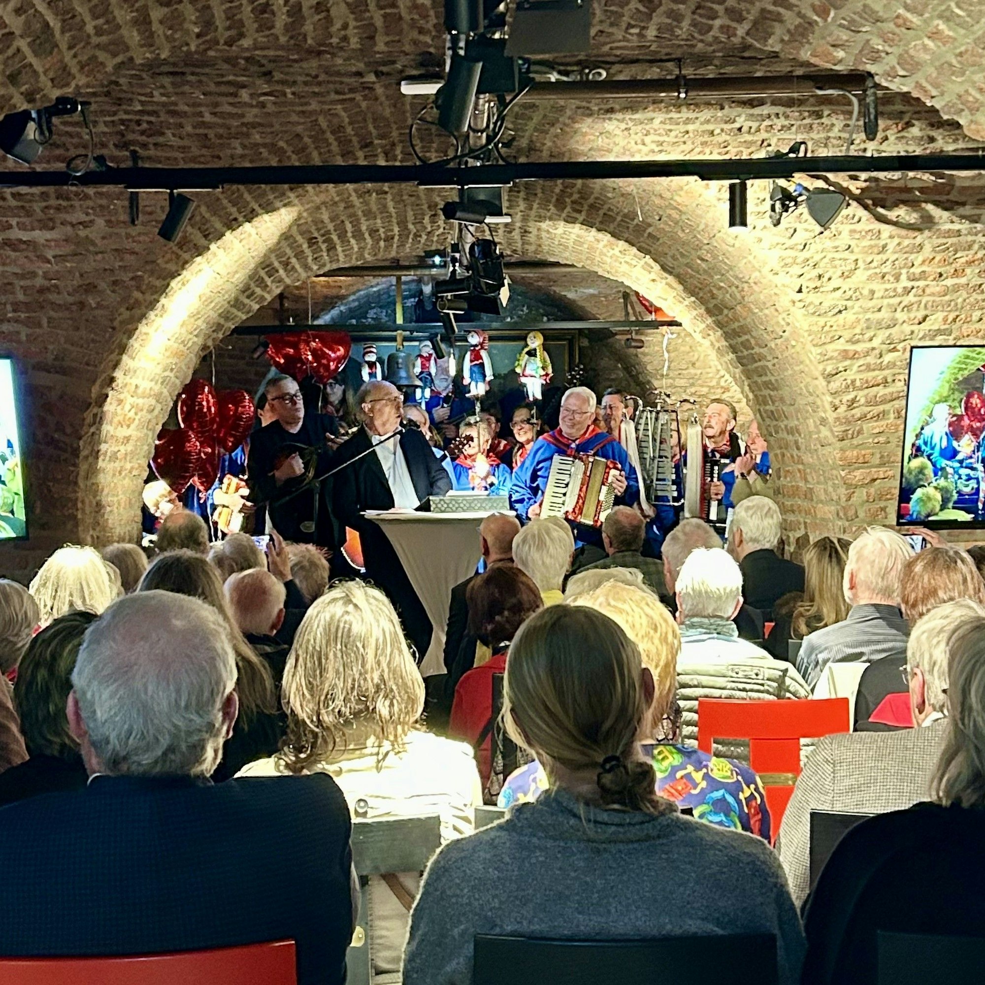 Der Laudator am Mikrofon steht auf der Bühne.