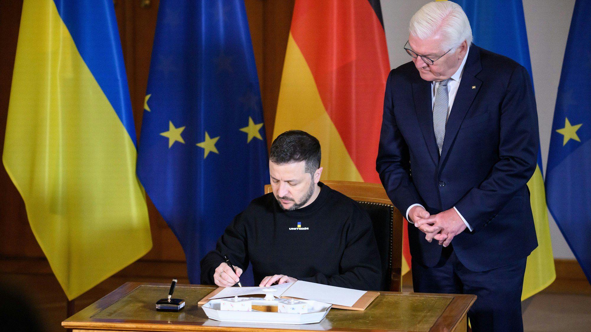 Wolodymyr Selenskyj, Präsident der Ukraine, trägt sich vor seinem Gespräch mit Bundespräsident Frank-Walter Steinmeier (r) in das Gästebuch im Schloss Bellevue ein.