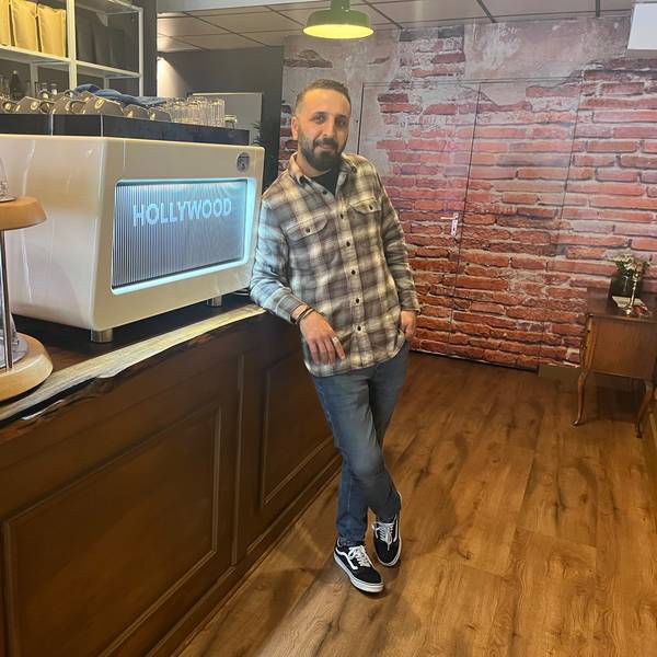 Erkan Pak steht angelehnt an der Theke seines Cafés „Bohnenfeld“ in Köln-Ehrenfeld.