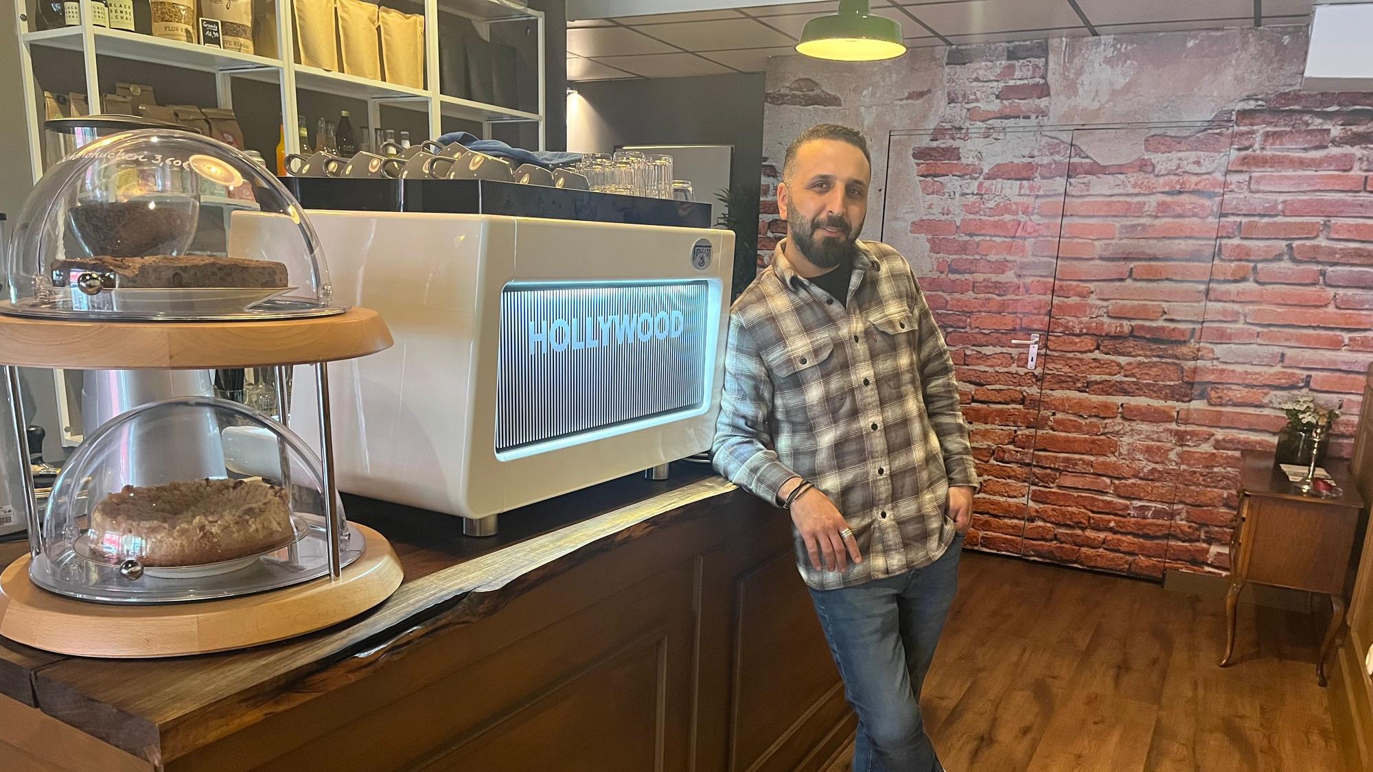 Erkan Pak steht angelehnt an der Theke seines Cafés „Bohnenfeld“ in Köln-Ehrenfeld.
