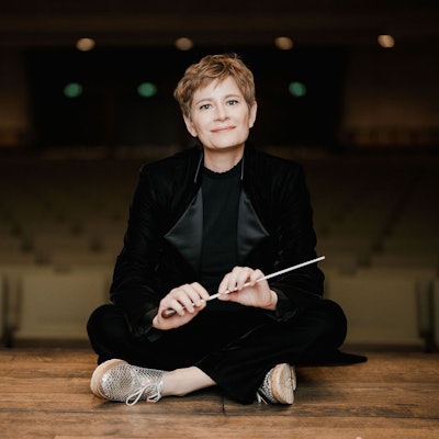 Anja Bihlmaier sitzt im Schneidersitz auf einer Bühne.