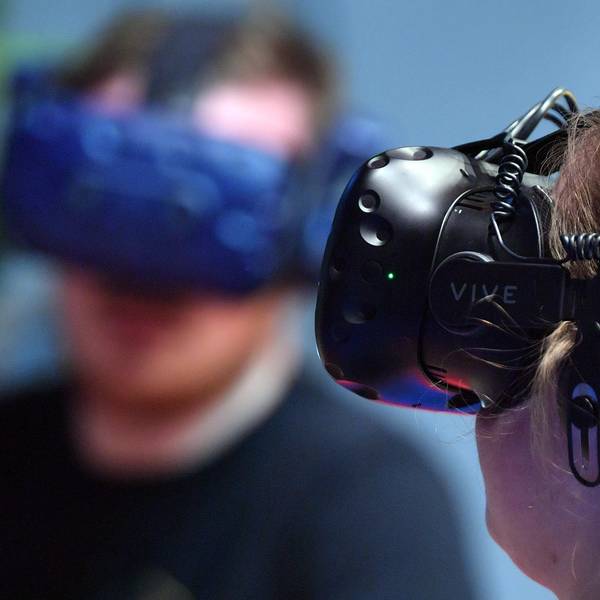Eine Frau trägt eine VR-Brille, mit deren Hilfe man in eine virtuelle Realität eintauchen kann.