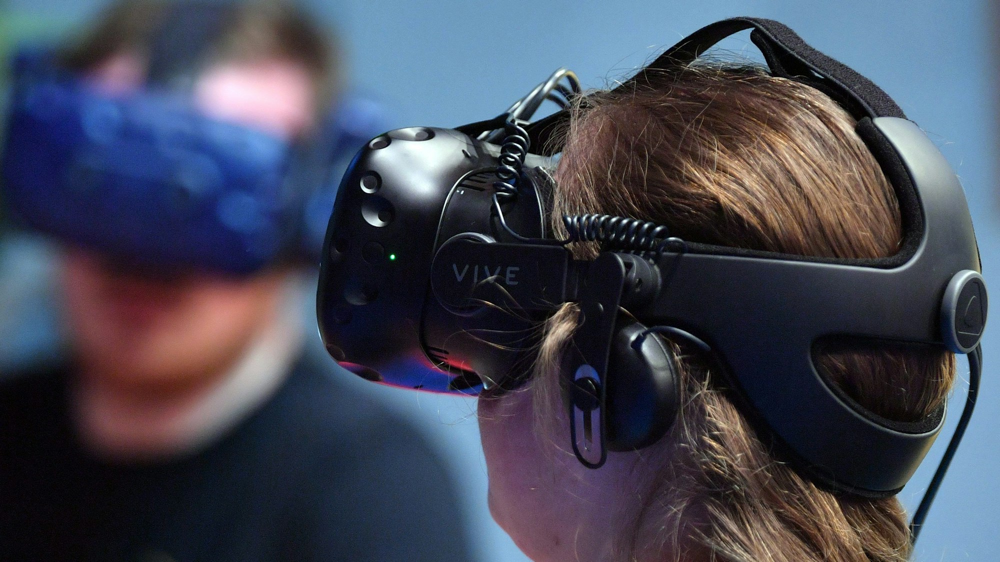 Eine Frau trägt eine VR-Brille, mit deren Hilfe man in eine virtuelle Realität eintauchen kann.