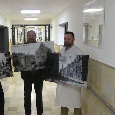 Josef Valenthorn, Geschäftsführer, Josef Wirges, Vorsitzender des Fördervereins und Adam Frey, Abteilungsleiter im St. Franziskus-Hospital, zeigen Bilder mit historischen Motiven von Köln und Ehrenfeld.
