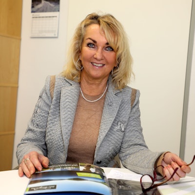 Gabi Wilhelm, die neue Geschäftsführerin des Tourismus-Büros „Das Bergische“ lächelt in die Kamera. Hinter ihr befinden sich Aktenordner in einem Regal.