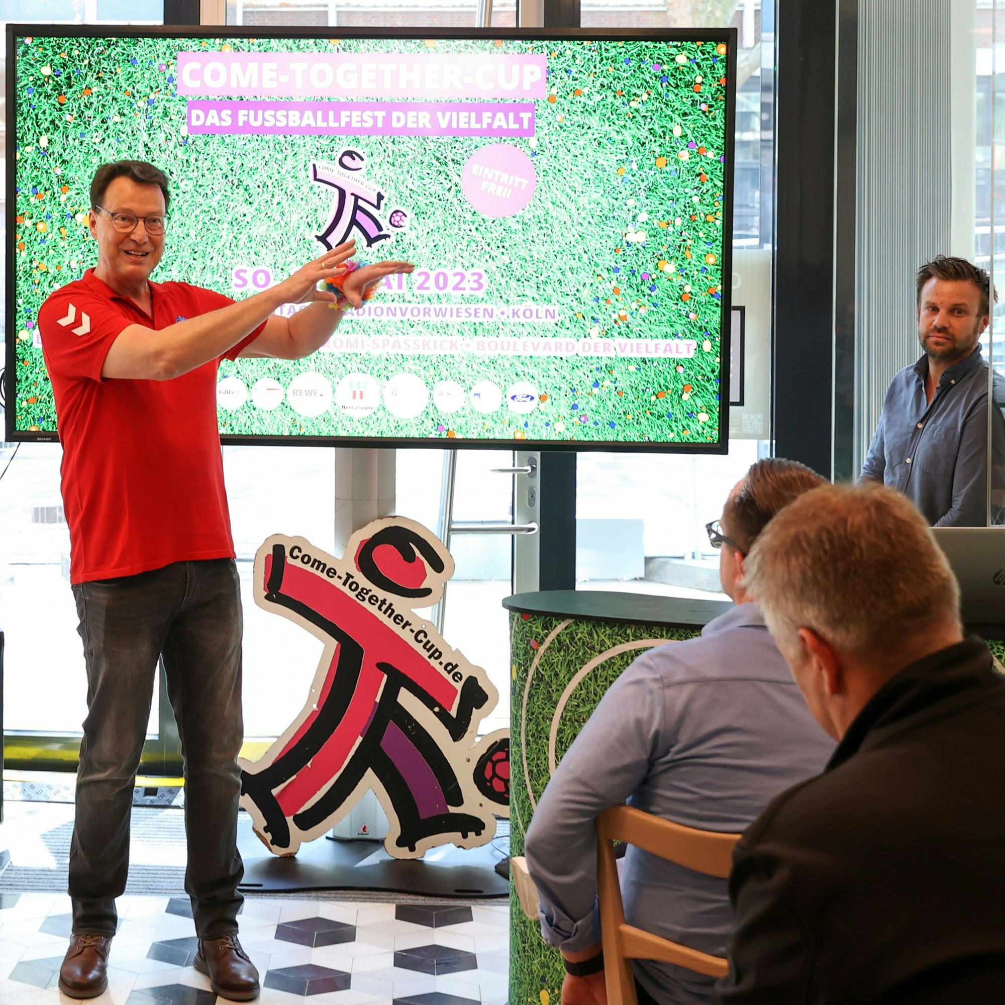 Andreas Stiene steht vor einem großen TV mit dem Plakat des CTC.