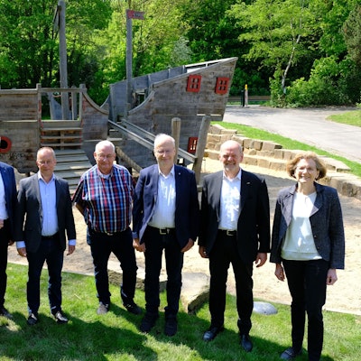 Auf dem frisch verlegten Rollrasen machten sich Vertreter der beteiligten Stellen ein Bild von den erfolgreich abgeschlossenen Sanierungsarbeiten im Mühlenpark.