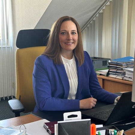 Nicole Berka sitzt an ihrem Schreibtisch.