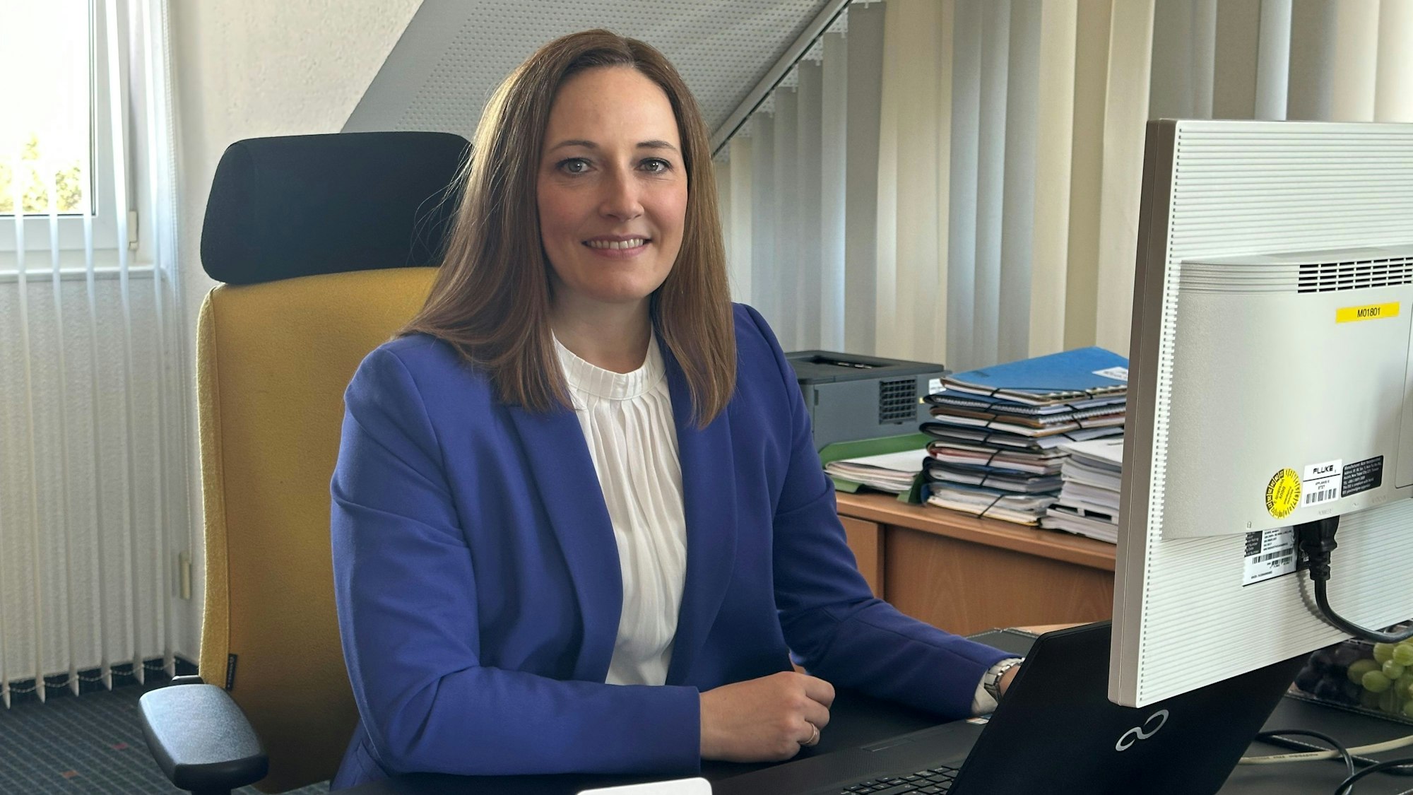 Nicole Berka sitzt an ihrem Schreibtisch.