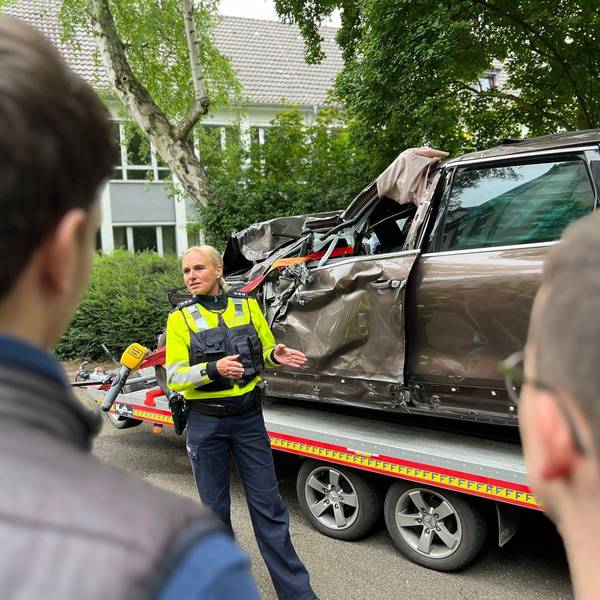 Hauptkommissarin Natalie Jung und Schüler stehen vor einem völlig demolierten Auto, dessen Fahrer bei einem Raser-Unfall gestorben ist.