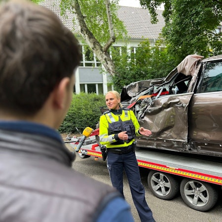 Hauptkommissarin Natalie Jung und Schüler stehen vor einem völlig demolierten Auto, dessen Fahrer bei einem Raser-Unfall gestorben ist.