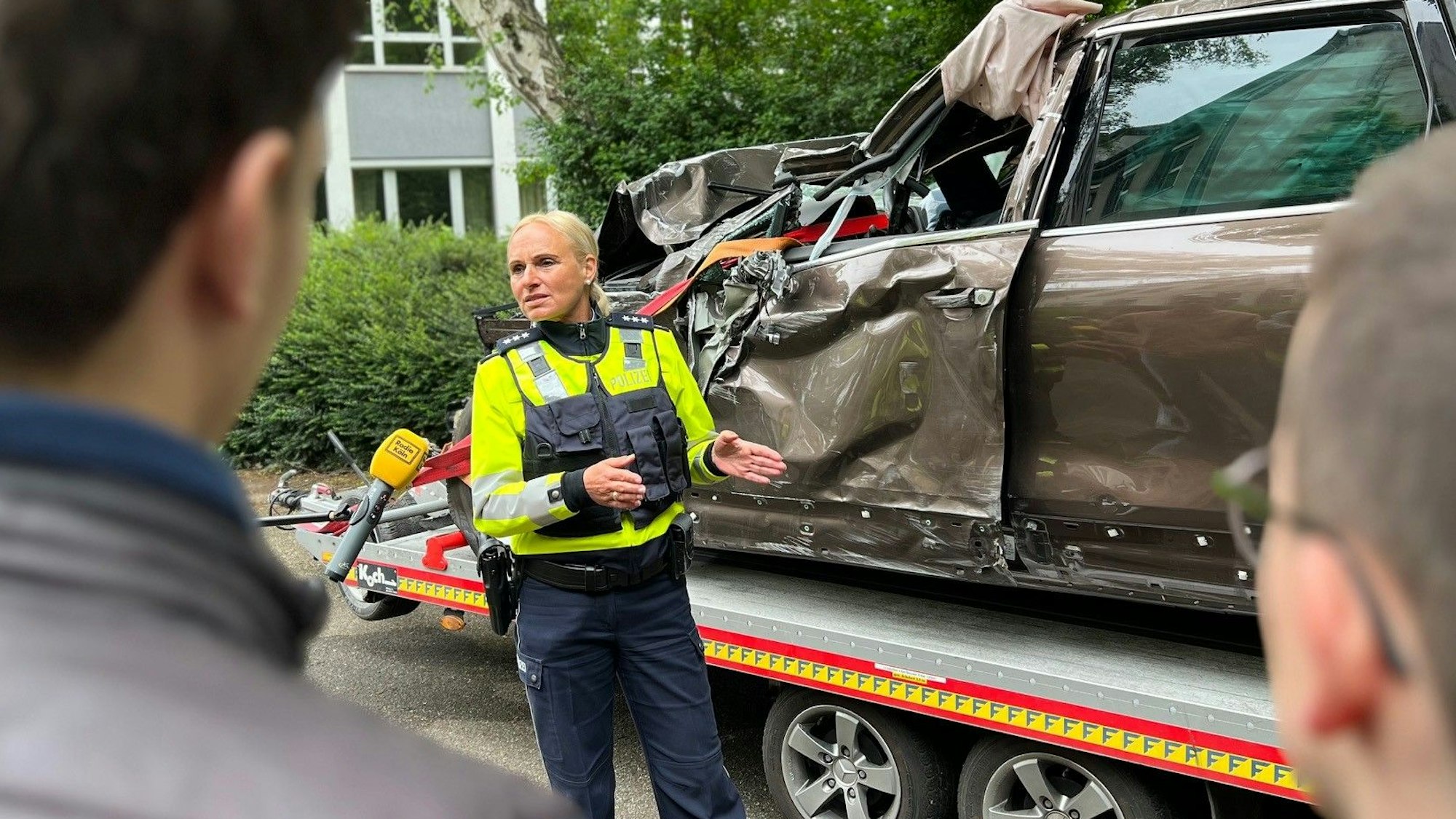 Hauptkommissarin Natalie Jung und Schüler stehen vor einem völlig demolierten Auto, dessen Fahrer bei einem Raser-Unfall gestorben ist.