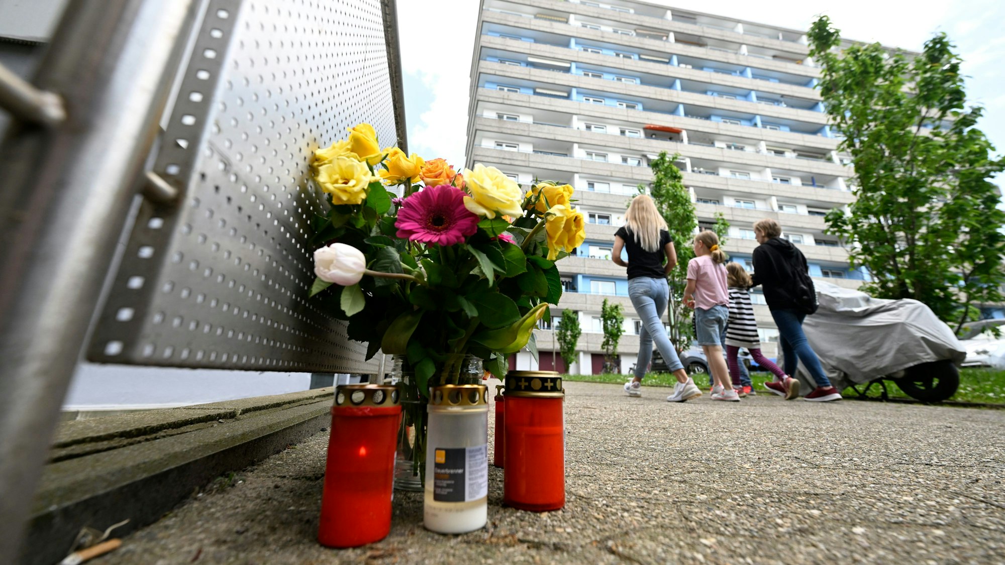 14.05.2023, Nordrhein-Westfalen, Ratingen: Bürger haben zum Gedenken an die Opfer der Explosion in einem Hochhaus, bei dem mehrere Einsatzkräfte von Polizei und Feuerwehr schwer verletzt wurden, am Tatort Kerzen und Blumen niedergelegt. Foto: Roberto Pfeil/dpa +++ dpa-Bildfunk +++