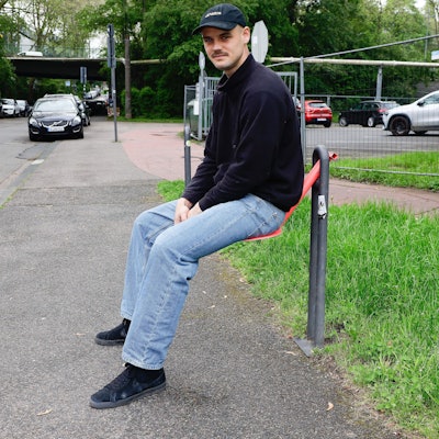 Friedel Schlör sitzt auf einem Stahl-Sitz.