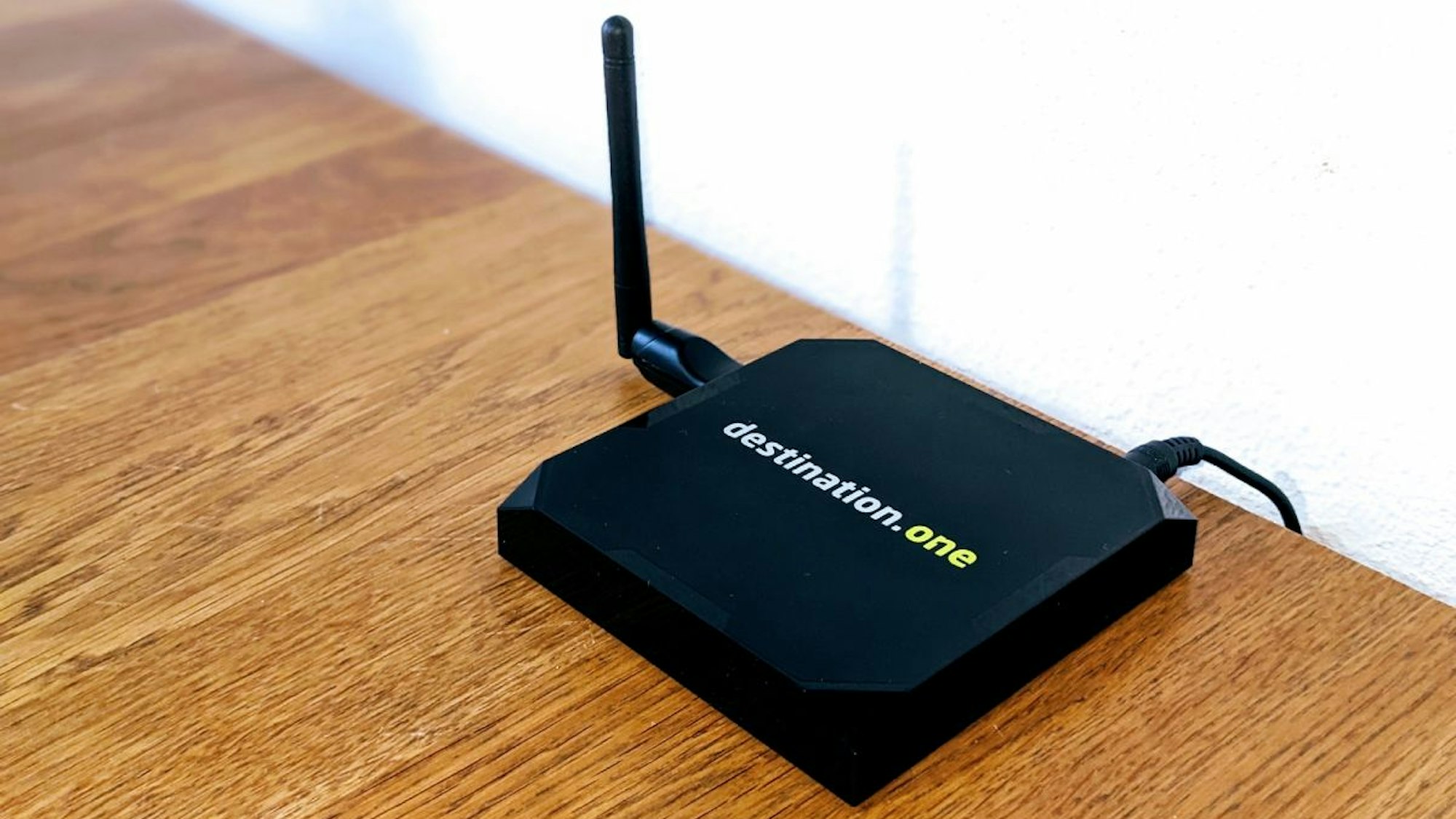 Ein schwarzer Wifi-Zähler steht auf einem hellbraunen Tisch. Die Aufschrift des Zählers besagt „destination.one“.
