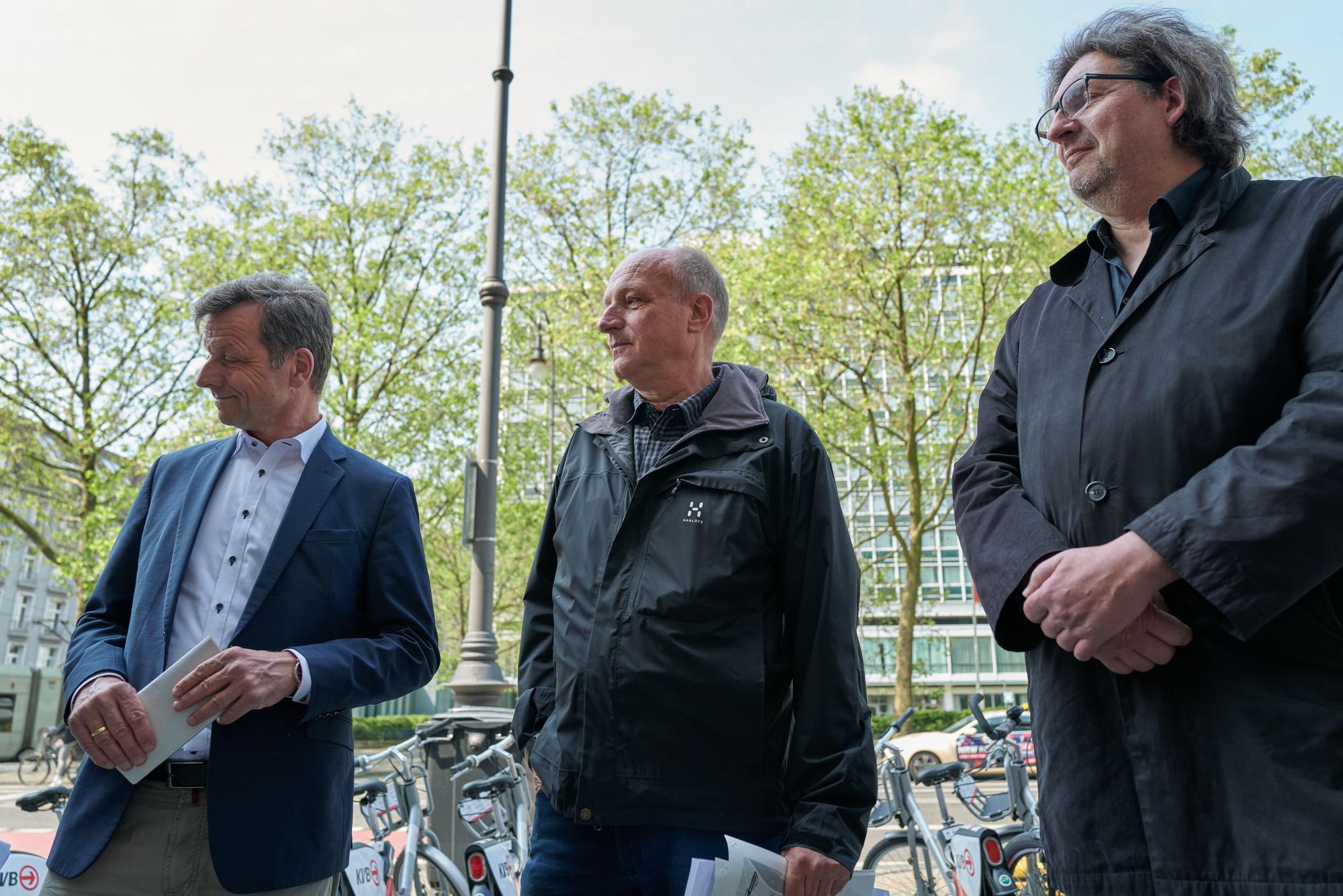 Drei Männer (Ascan Egerer, Jürgen Möllers, Reinhold Goss) stehen auf den Kölner Ringen und schauen auf Fahrradspuren.