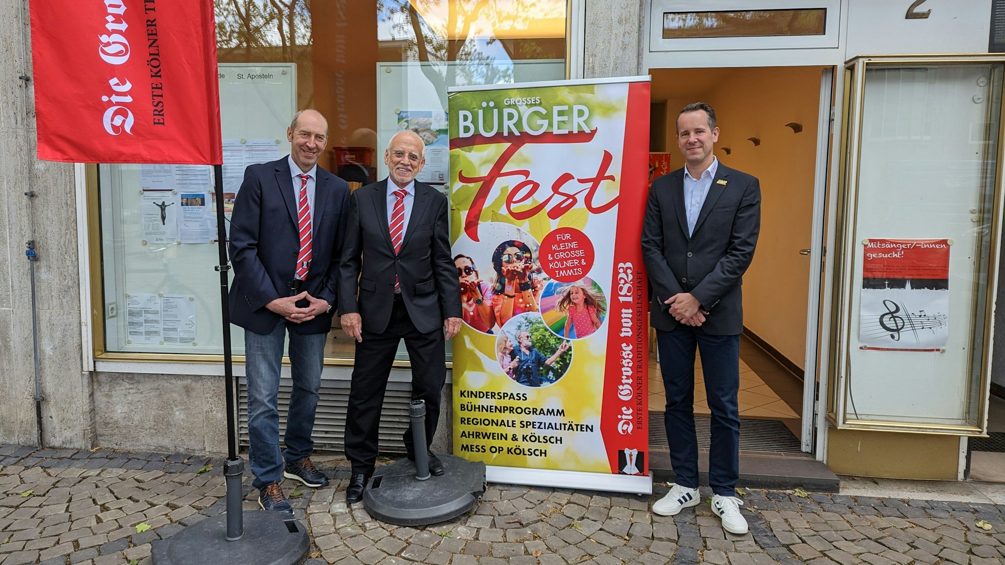 Die Organisatoren stehen neben einem Aufsteller, der das Bürgerfest bewirbt.