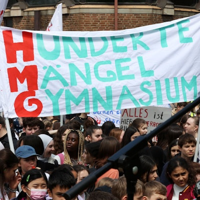 Schülerinnen und Schüler mit Fahnen und Plakaten in der Hand.