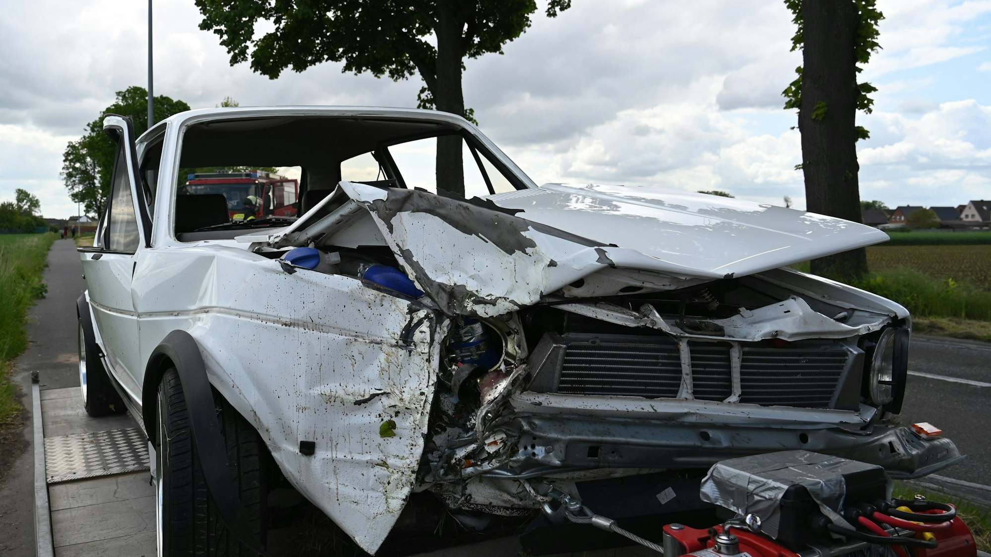 Das Bild zeigt einen im Frontbereich beschädigten weißen VW-Golf I.