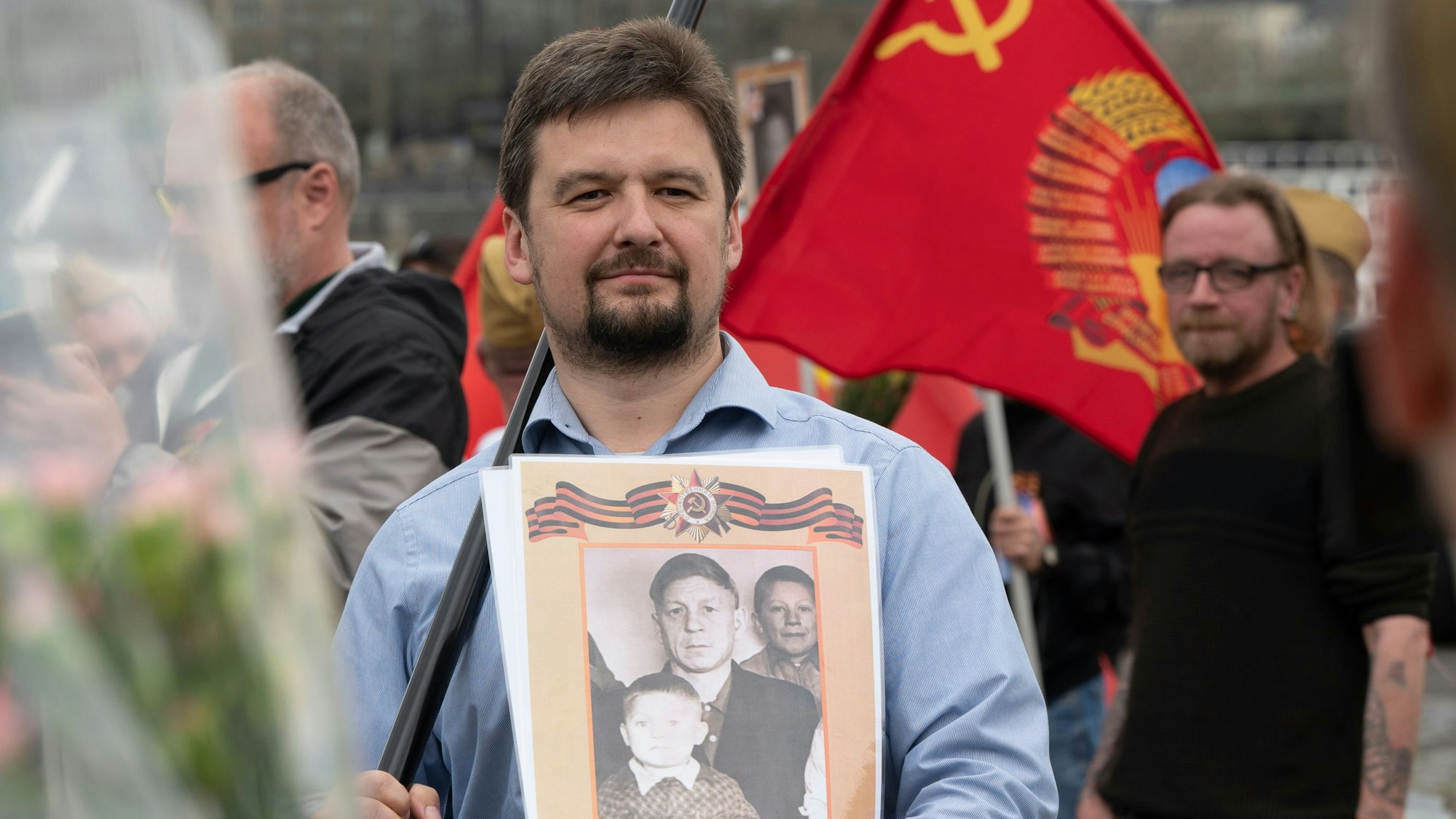 Seewald läuft bei einer pro-russischen Demo in Köln mit. In der Hand hält er ein Plakat mit Foto auf russisch und eine Fahnenstange. Foto: Uwe Weiser