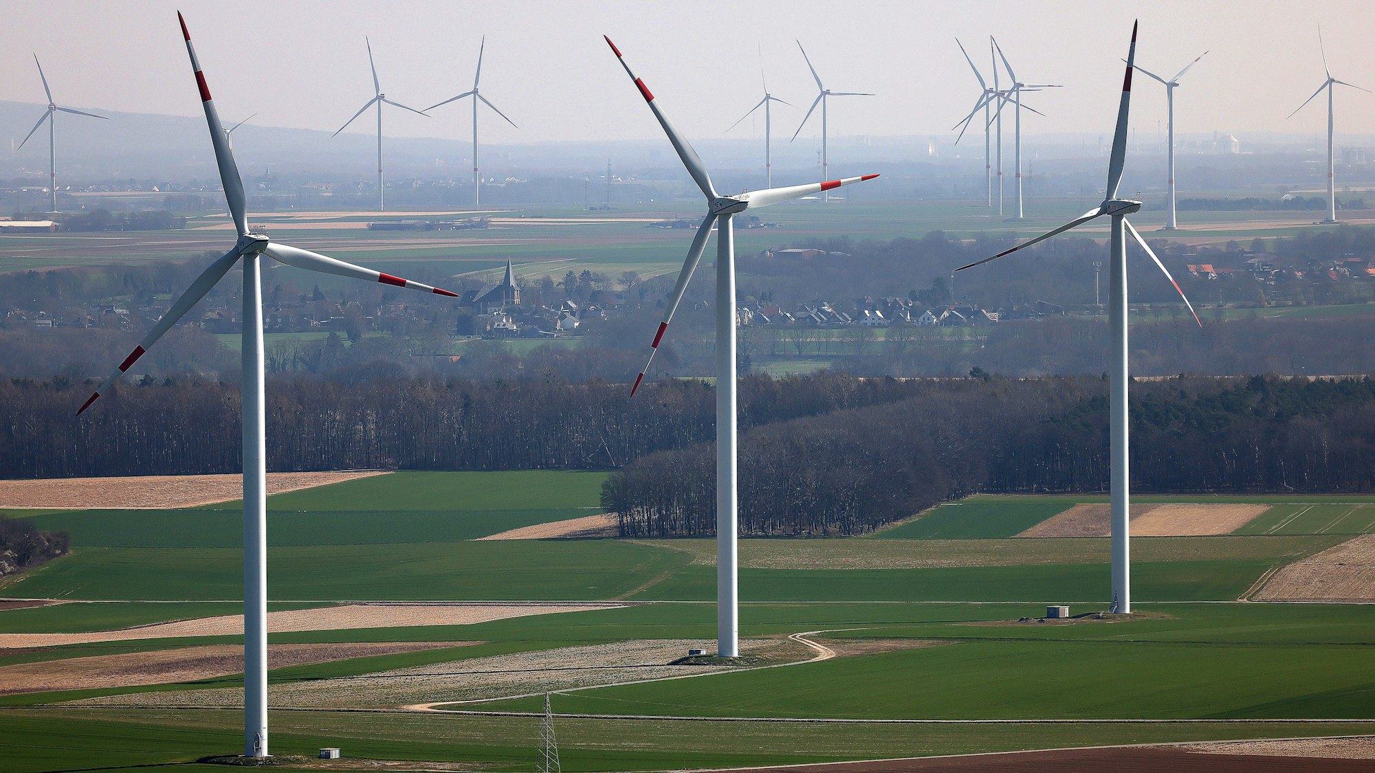 ARCHIV - 22.03.2022, Nordrhein-Westfalen, Heinsberg: Windräder einer Windenergieanlage des Landesverbandes Erneuerbare Energien NRW (LEE NRW) drehen sich im Windpark Heinsberg-Straeten. Beim Ausbau von Windrädern an Land ist aus Sicht der Branche ein Ende der Flaute in Sicht. (zu dpa: «Bei Windrädern ist Ende der Ausbauflaute in Sicht») Foto: Oliver Berg/dpa +++ dpa-Bildfunk +++