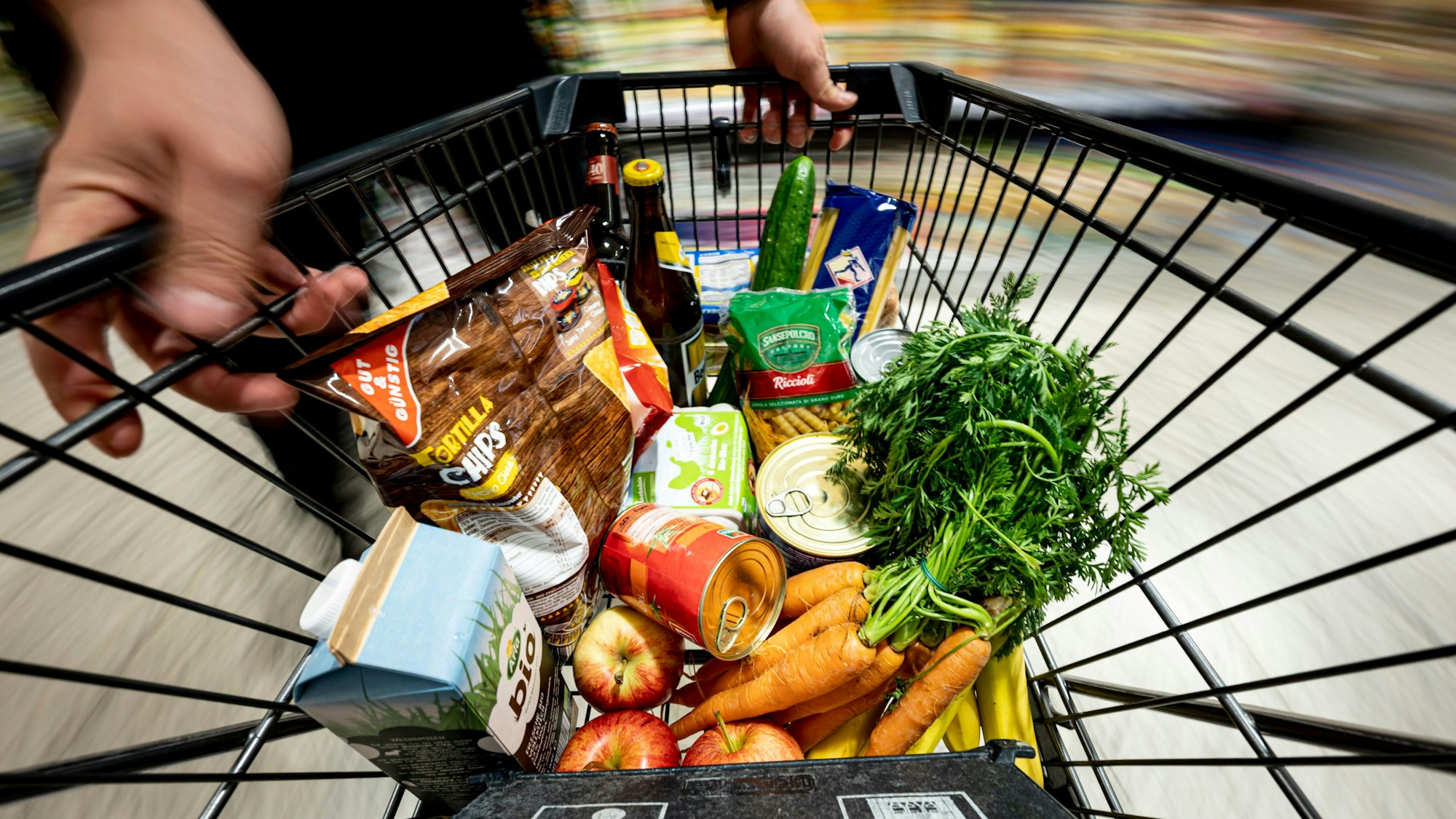 Einkäufe liegen in einem Einkaufswagen. Die Preise steigen weiterhin stark, nach Ansicht der Verbraucherzentrale sogar zu stark. (Symbolbild)
